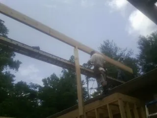 Carpenter setting a ridge beam over a new addition frame — Ice Dam Removal by Roofing Brothers in Murrieta
